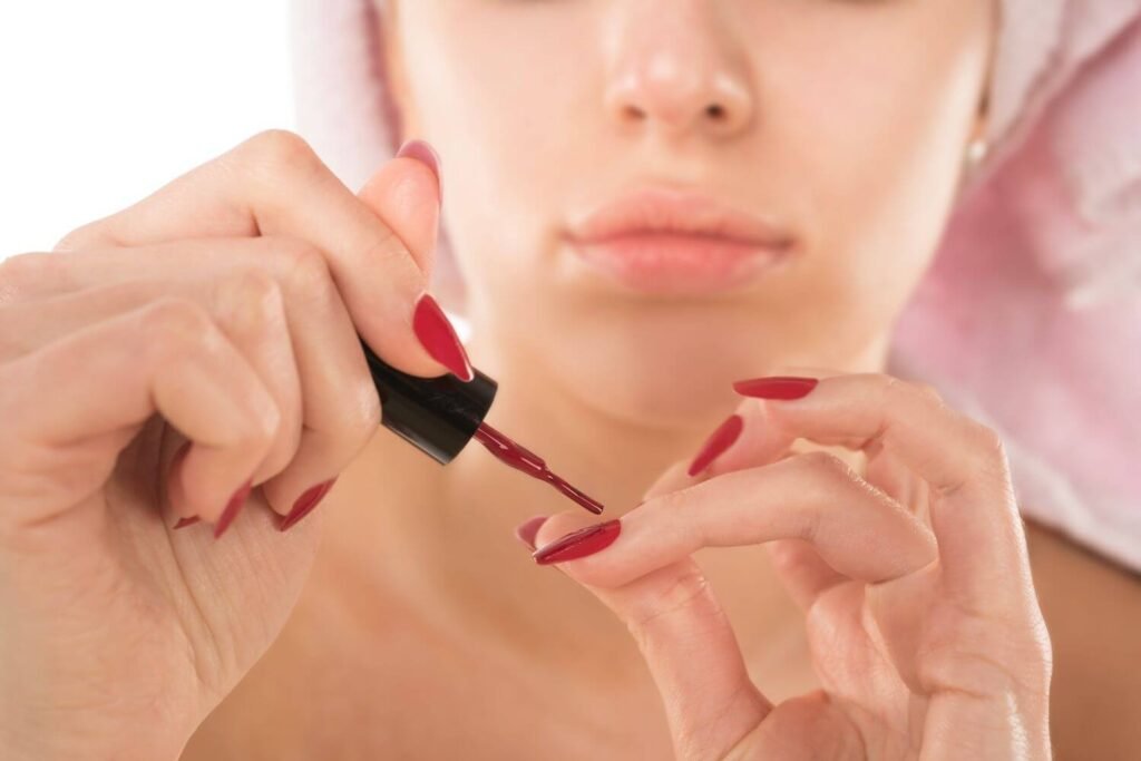 Jeune femme appliquant le vernis à ongles idéal
